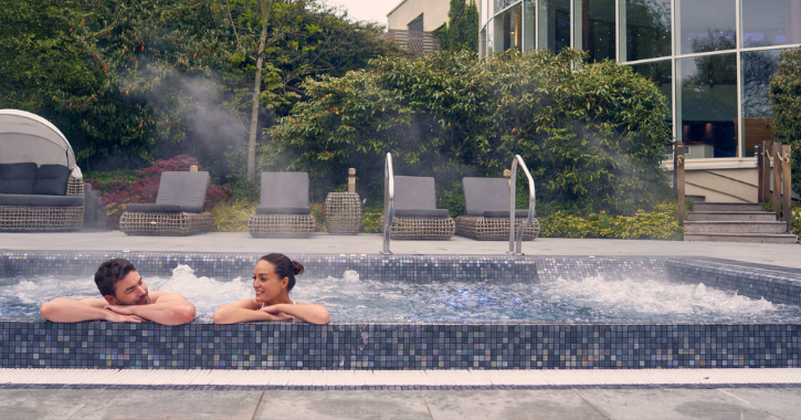 man and woman sat relaxing in outdoor pool at Seaham Hall Serenity Spa.